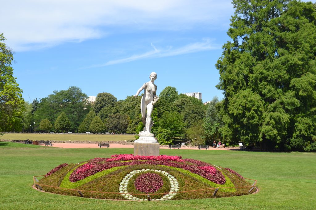 Photo d'un parterre de fleurs surmontés d'une statue blanche