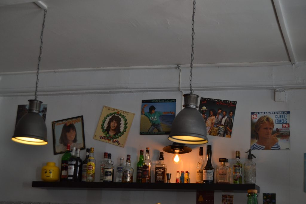 Photo des étagères contre le mur avec des bouteilles et les affiches