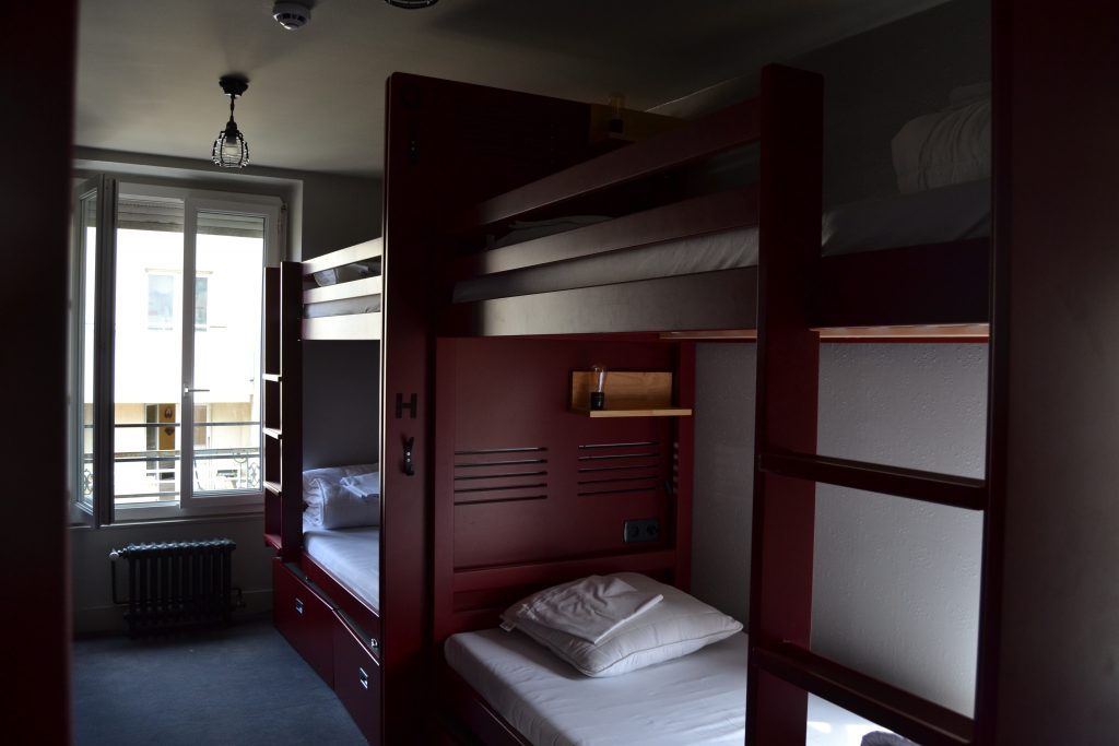 Photo des lits superposés peints en rouge dans une des chambres communes