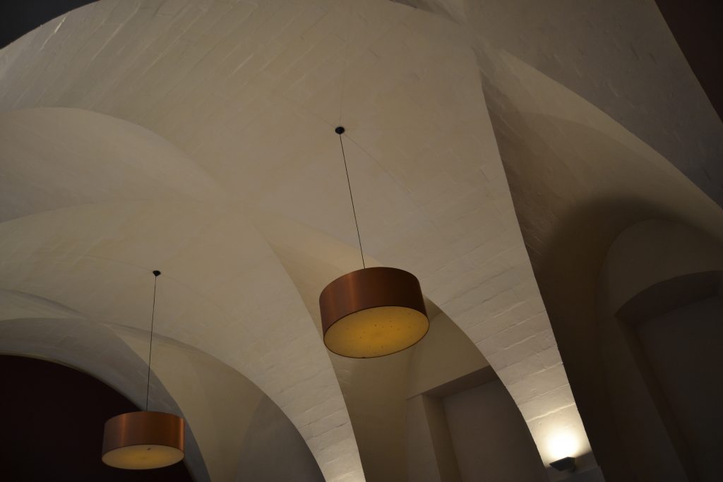 Photo du plafond avec ses grands luminaires et les voûtes