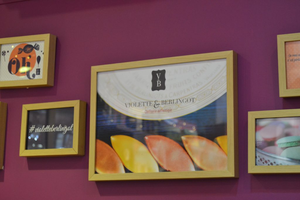 Photo du mur derrière le comptoir de la boutique avec des affiches à l'effigie de Violette & Berlingot