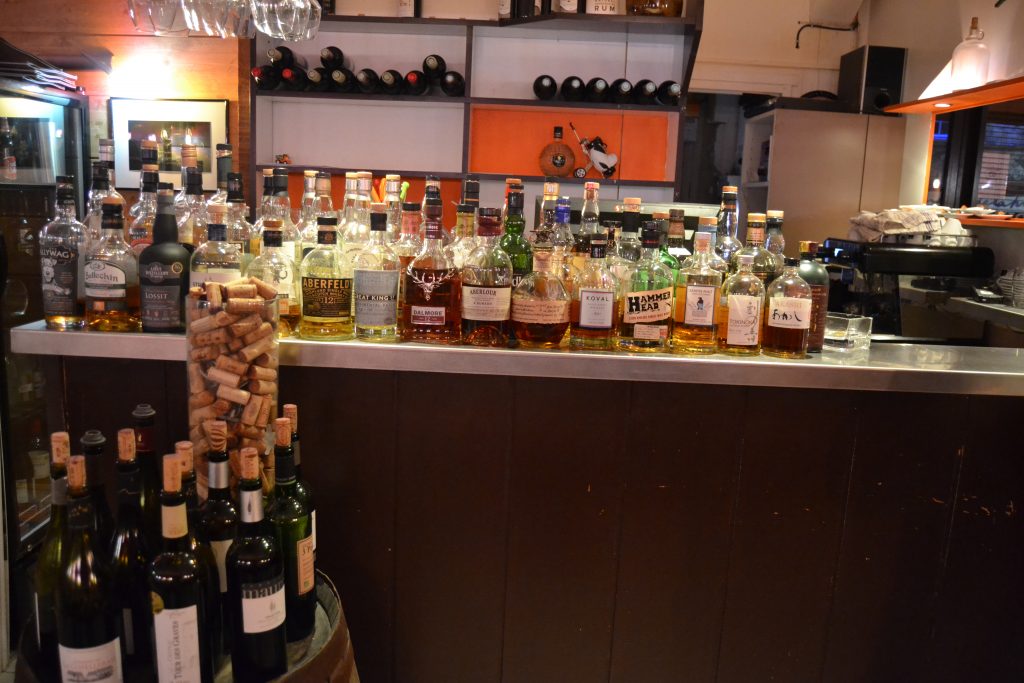 Photo du comptoir avec toutes les bouteilles de whisky