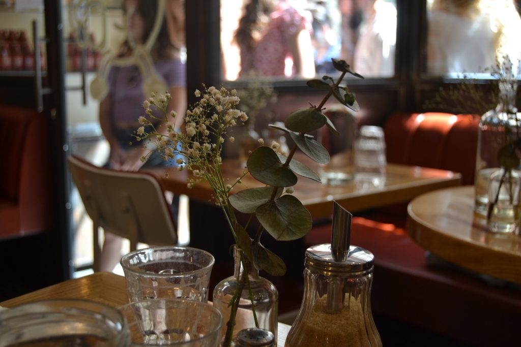 Photo des tables de la salle avec des bouquets d'eucalyptus dessus