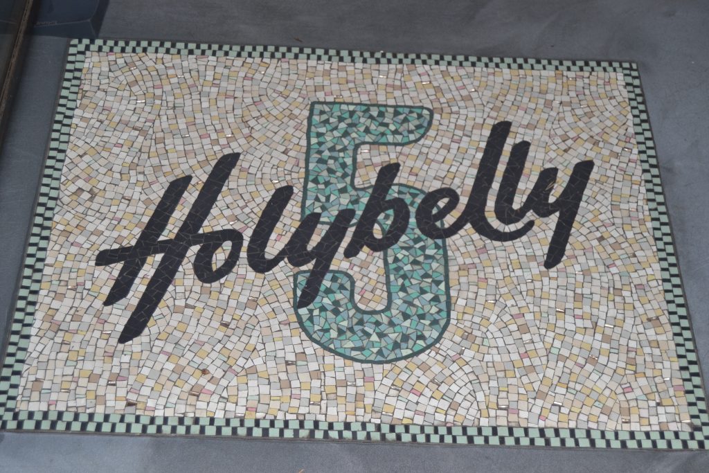 Photo de l'entrée où est inscrit sur le sol Holybelly 5 en mosaïque